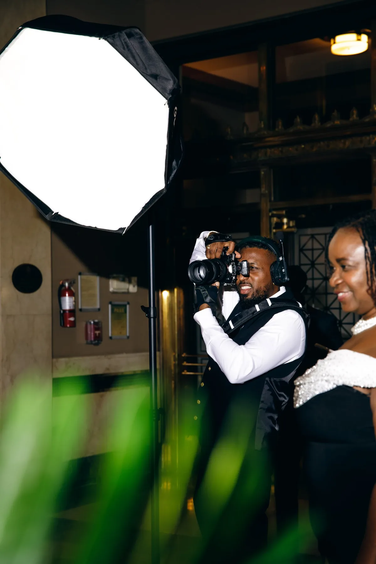 Sean Diamond photographing guests at an evening event, beside a softbox